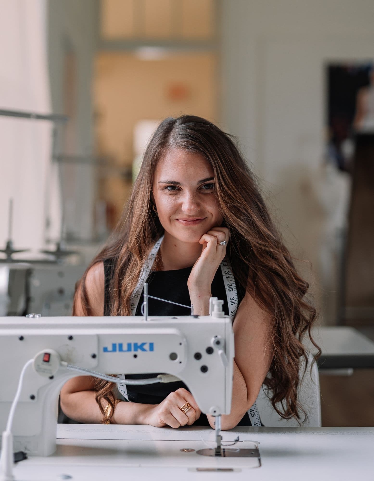 Samantha Covey at the sewing machine Samantha Covey seated at a Juki sewing machine in her atelier.